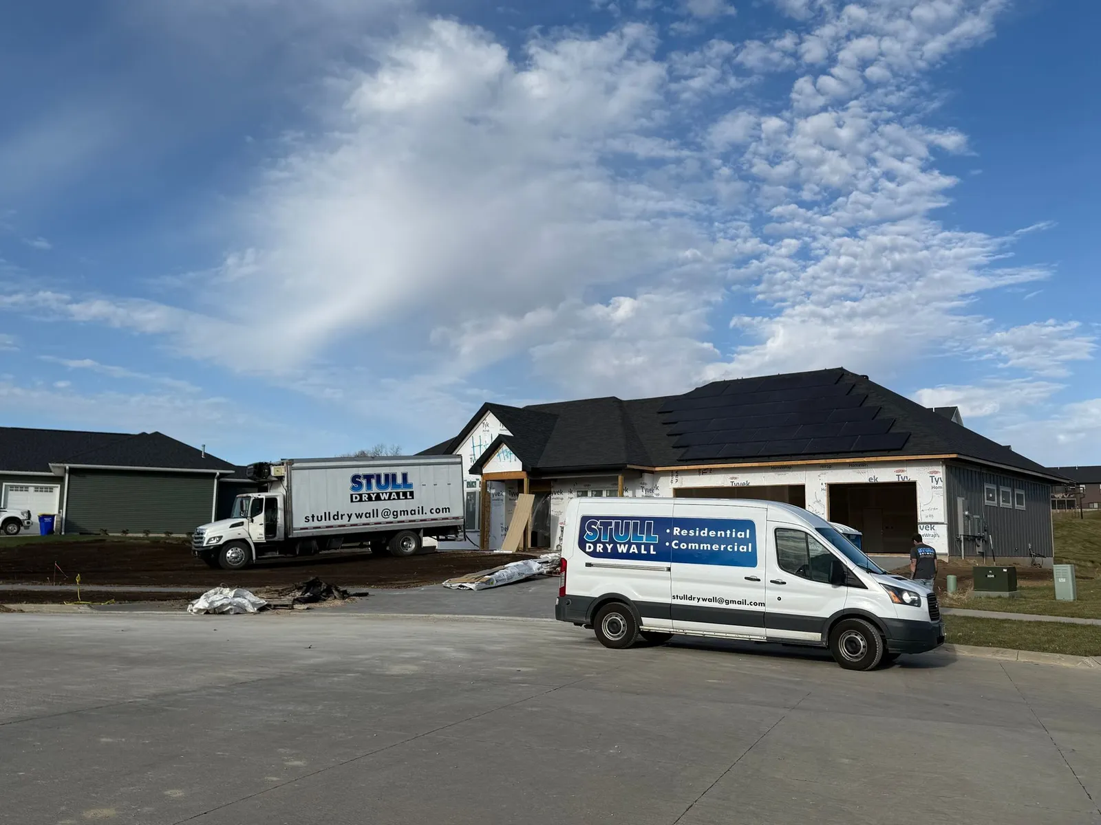 Stull Drywall trucks at a residential construction site